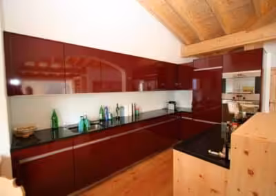 Hochglanz Weinrot mit Griffleisten und Naturstein