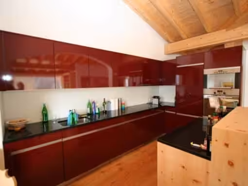 Hochglanz Weinrot mit Griffleisten und Naturstein